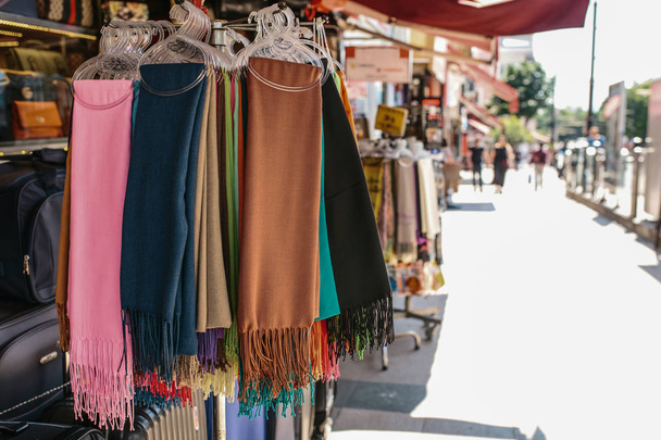 Gyűjteménye színes textil sál a fogas, az utcai árusok fülkében, szabadtéri bevásárló negyed megtekintése napközben szabadban kiállítva. - Fotó, kép
