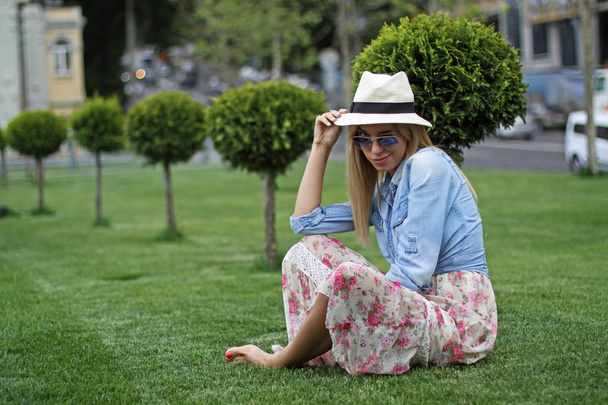 Дівчина в капелюсі на зеленому газоні
 - Фото, зображення