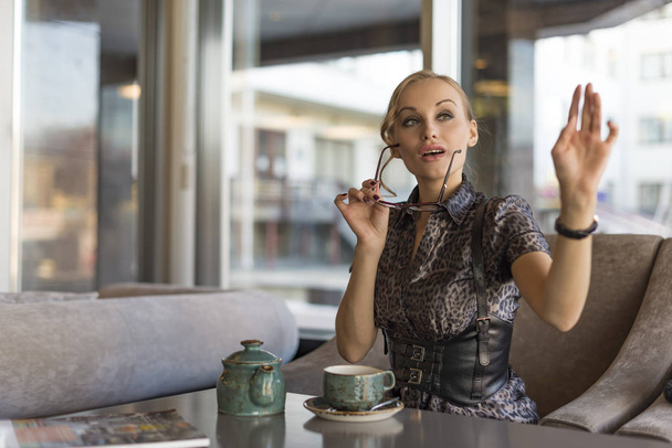 şık iş kadını kahve dükkanında iş öğle yemeği molası kafede bir fatura isteyen kadın yönetici, tüketicinin otururken garson için çağrı - Fotoğraf, Görsel