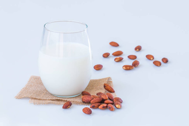 Almond milk in a glass   with  almond seeds on marble table.  - Zdjęcie, obraz