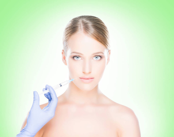 Doctor making injection into face of woman - Foto, immagini