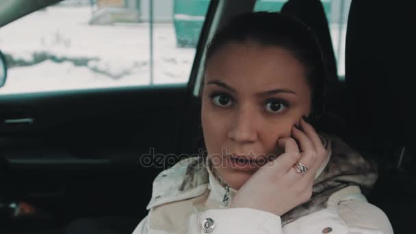 Przestraszony młoda kobieta rozmowy na telefon komórkowy, siedząc w samochodzie - Materiał filmowy, wideo
