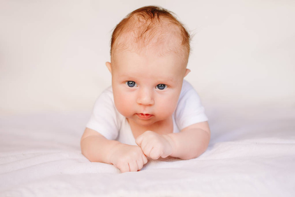 Caucasian baby on bed - Фото, изображение