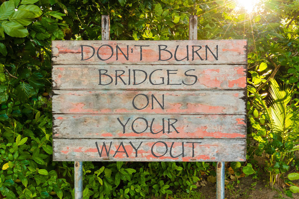 Ne Burn Bridges a Your Way Out motivációs írt a régi vintage fórumon bejelentkezés a forrest, a nap sugarai a háttérben. - Fotó, kép