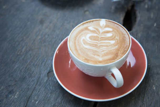 above cup of hot latte art coffee on wooden table. - Φωτογραφία, εικόνα