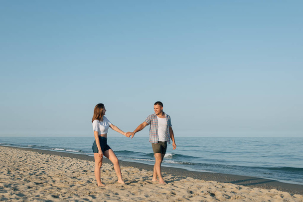 Para, trzymając się za ręce, spacery po plaży - Zdjęcie, obraz