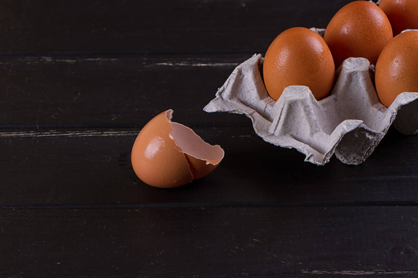 Siyah ahşap zemin üzerine karton yumurta kutusu - Fotoğraf, Görsel