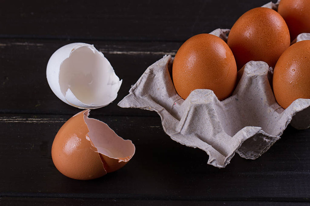 Siyah ahşap zemin üzerine karton yumurta kutusu - Fotoğraf, Görsel