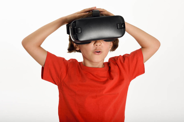 Little girl looking in VR glasses and gesturing with his hands. - Photo, Image