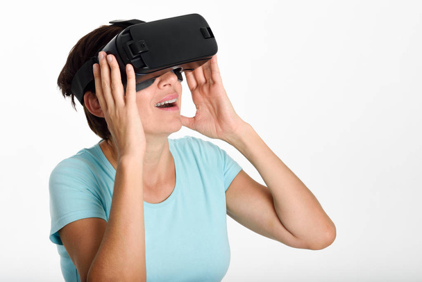 Woman looking in VR glasses and gesturing with his hands. - Photo, Image