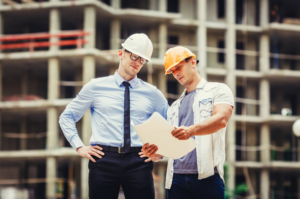 Architect and builder discussing at construction site - 写真・画像