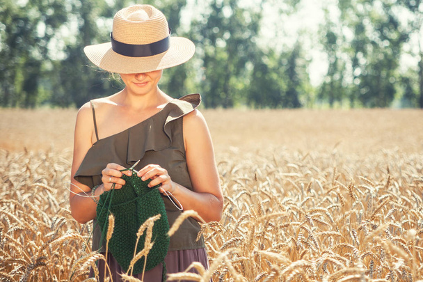 genç kadın buğday sahada örgü - Fotoğraf, Görsel