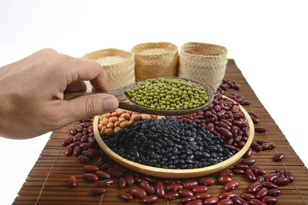 Zrna obilovin a semen fazole (černé fazole, Red Bean, arašídové, mungo, thajské jasmínové rýže, hnědá rýže a bílé rýže) užitečné pro zdraví v dřevěné lžíce na bílém pozadí. - Fotografie, Obrázek
