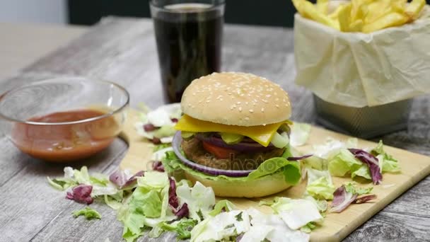 Flecha panorámica en Delicosa hamburguesa casera con papas fritas en mesa de madera
 - Metraje, vídeo