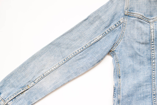 Flat lay part of jeans jacket on white background - Foto, Imagem