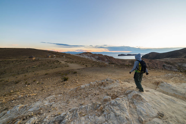 Backpacker zwiedzania majestatycznych Inca Trails na wyspę słońca, jezioro Titicaca, wśród najbardziej malowniczych podróż przeznaczenia w Boliwii. Przygody podróży i wakacji w Ameryce. Stonowanych obrazów. - Zdjęcie, obraz