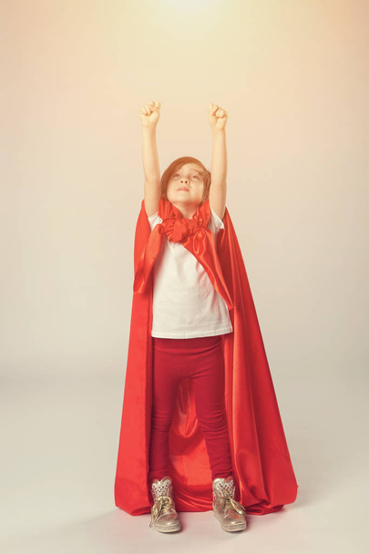 Superhrdina dívka v červených cape zvedla ruce nahoru - Fotografie, Obrázek
