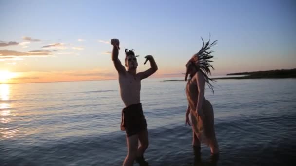 Indiánské indicky krásný muž a ženy tančí na pláži moře s slunce při západu slunce - Záběry, video