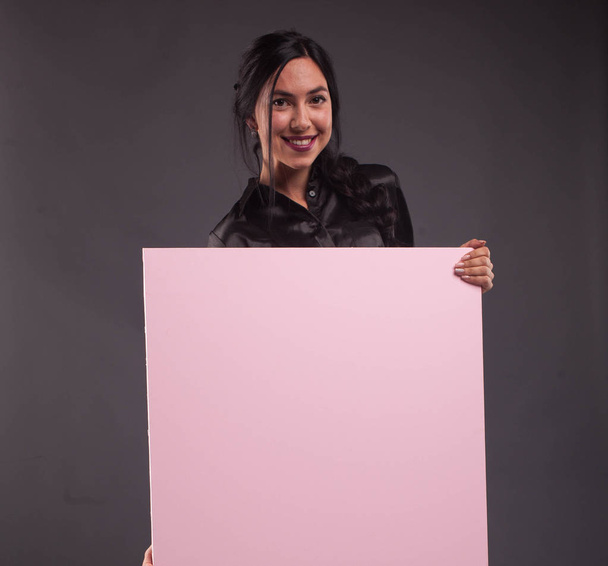 Young happy woman showing presentation, pointing on placard - Foto, Bild