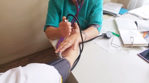 Lekarz mierzy ciśnienie pacjentowi krwi - Materiał filmowy, wideo