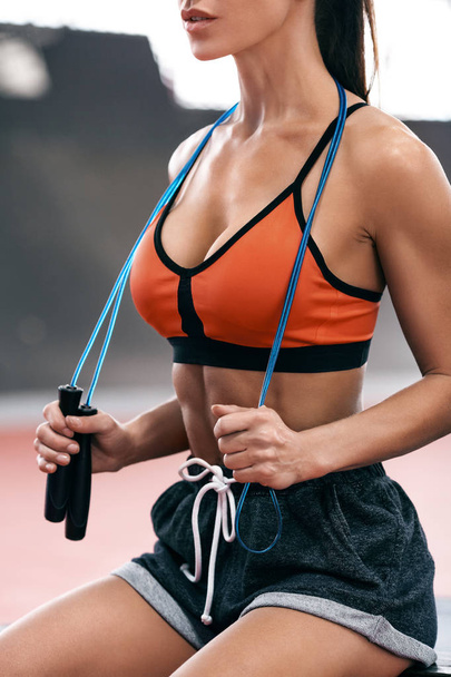Belle femme de fitness avec corde à sauter, séance d'entraînement. Sexy fille athlétique, concept sportif
 - Photo, image