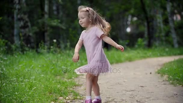 Dítě otáčí a tančí v parku, pomalý pohyb - Záběry, video