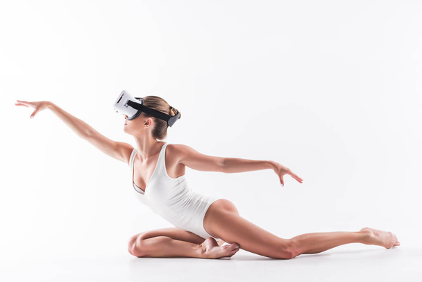 Solemn youthful girl exercising on floor with goggles on eyes - Photo, image