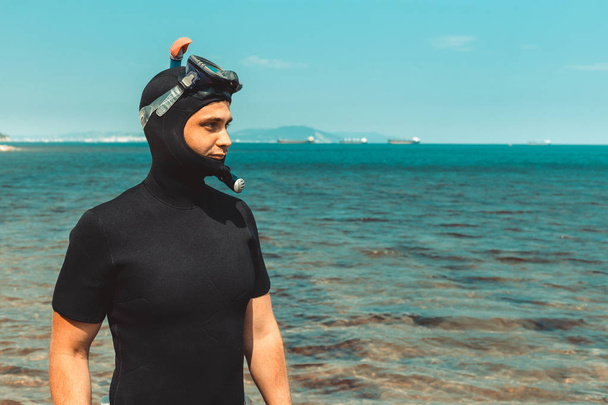 Junger Mann im Taucheranzug geht im Sommer ins Meer - Foto, Bild
