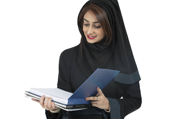 Αραβικά φοιτητής φορώντας abaya, κρατώντας το μπλε βιβλίο - Φωτογραφία, εικόνα