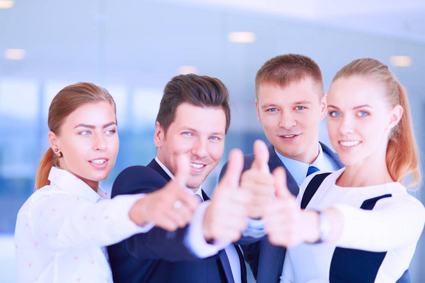 Счастливая бизнес-команда, демонстрирующая большие пальцы в офисе
 - Фото, изображение
