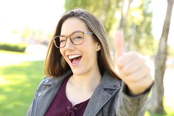 Забавная девушка в очках с поднятыми пальцами
 - Фото, изображение