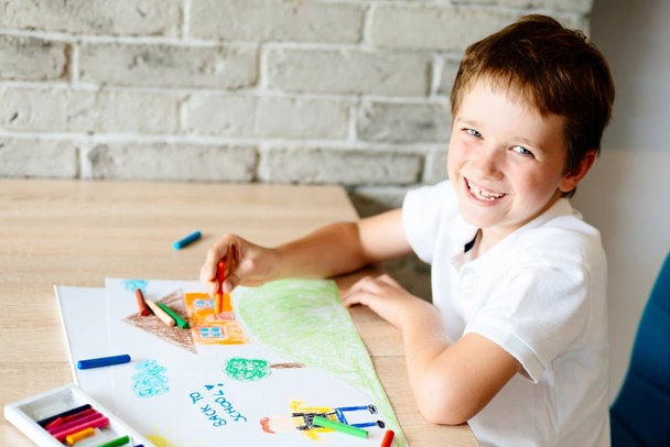 Kind zeichnet Bild eines Jungen, der zur Schule geht. - Foto, Bild