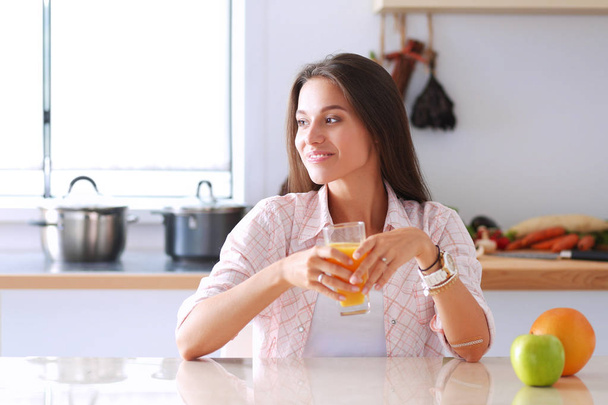 Young woman sitting a table in the kitchen - Photo, Image
