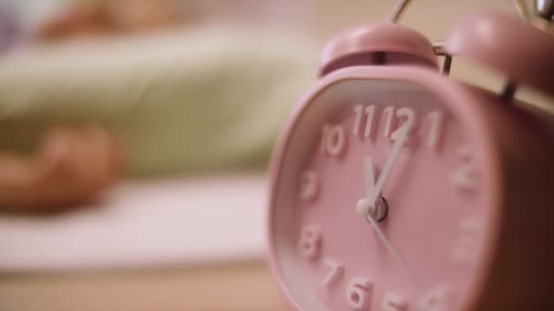 ピンクの目覚まし時計。ピンクのナイト テーブルの上にクロック立って - 映像、動画