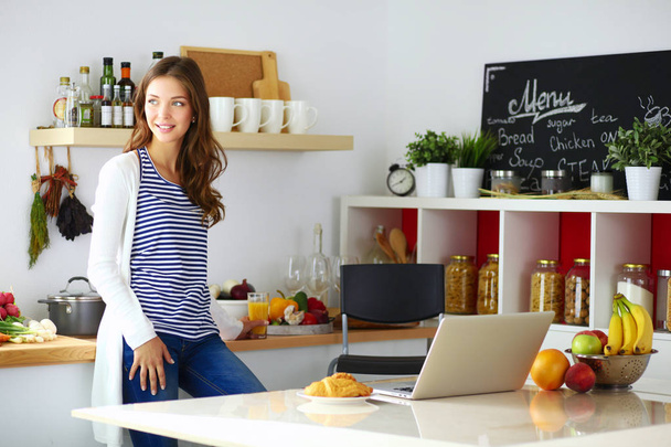 Young woman standing near desk in the kitchen - Photo, image