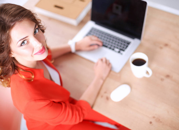 Attractive woman sitting at desk in office, working with laptop computer - Фото, зображення
