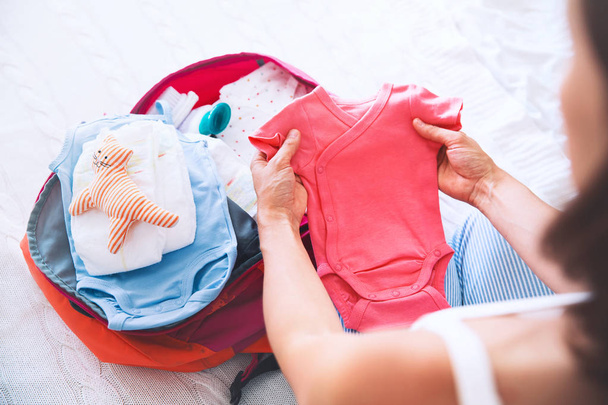 Pregnant woman packing suitcase, bag for maternity hospital - Photo, Image
