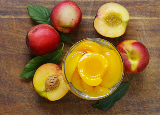 Luonnonmukaiset hedelmät, kypsät makeat purkitetut persikat
 - Valokuva, kuva
