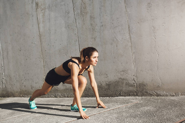 Atleta donna pronta a iniziare a correre nella giungla di cemento. Concetto sportivo urbano
. - Foto, immagini