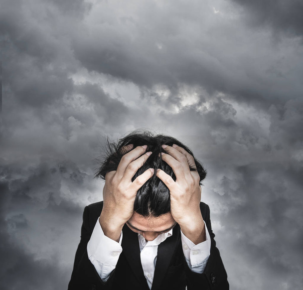 Stresovaní podnikatel, s pozadím temná bouřková mračna - Fotografie, Obrázek