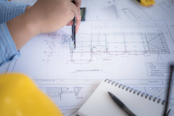 Arquitecto o planificador trabajando en dibujos para planos de construcción en una mesa - Foto, Imagen