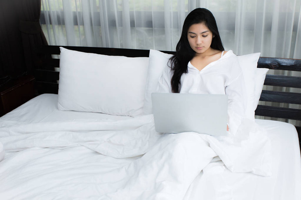 Frau benutzt Laptop auf ihrem Bett - Foto, Bild