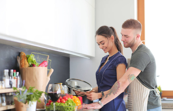 Couple cooking together in their kitchen at home - Photo, Image