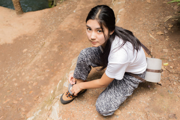 Ázsiai nő köti a cipő az erdő - Fotó, kép