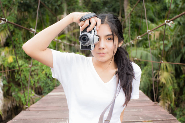 Asian woman taking photos outdoors in a forest - Foto, Bild