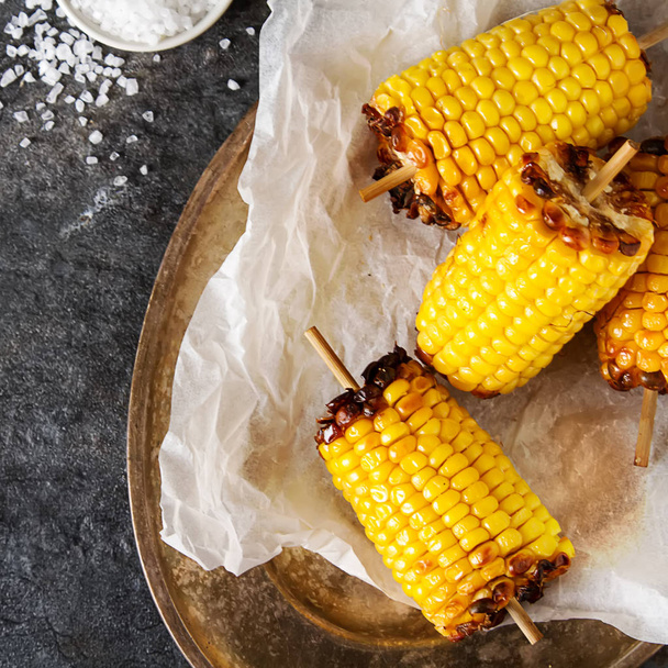 Corn grilled with salt and spices. Dark background. Fast food in - Φωτογραφία, εικόνα