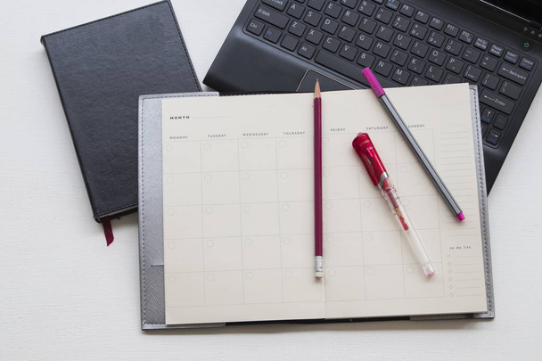 notebook monthly planner and computer for business on white  - 写真・画像