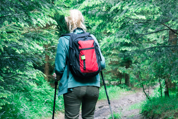 Una joven rubia haciendo senderismo en las montañas
 - Foto, imagen