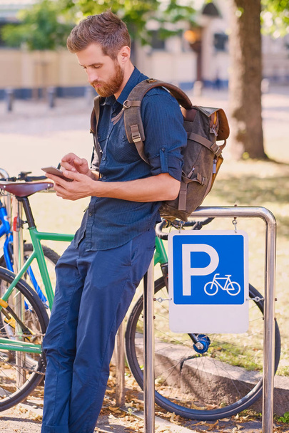 Man with smartphone near bicycles - Фото, зображення