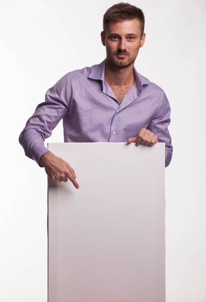 Young confident man showing presentation, pointing on placard - Foto, Imagem